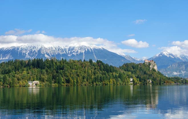 Panoramic view at the Bleder Lake with its iconic Burg at a Cliff and snow-covered Alpine peaks a symbol for Nature conservation, Alpine Biodiversity and sustainable Tourism in a untouched Environment 1135900203