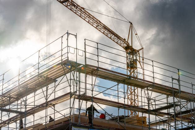 Mindelheim, Bavaria, Germany - March 12, 2026: A gloomy construction site with a crane and scaffolding against a backdrop of storm clouds shows the construction of new buildings. Housing construction and building projects are often the focus of political discussions about housing shortages, construction policy, construction acceleration programs, and jobs in the construction industry.