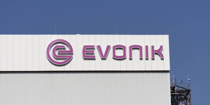 Nahaufnahme des Evonik-Logos an einem Industriegebäude in Wesseling Detailansicht des lila Evonik-Firmenlogos auf einer weißen Wellblechfassade am Chemiestandort Wesseling unter blauem Himmel. (License=RM) Copyright: xZoonar.com GERDxHARDERx 24784981
