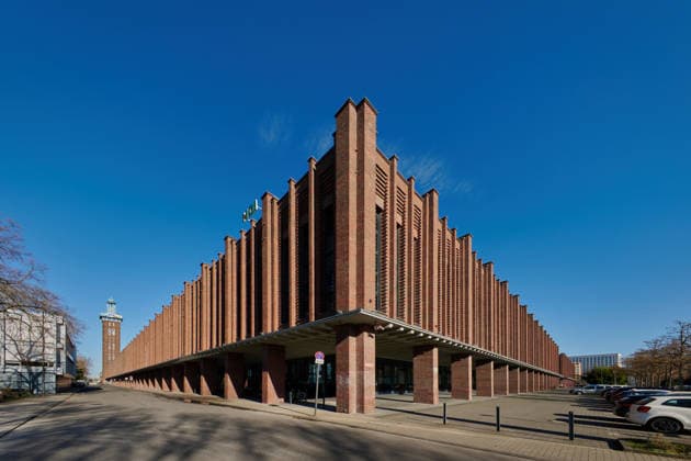 Moderne Backsteinarchitektur der Rheinhallen in Köln Geometrische Backsteinfassade der ehemaligen Kölner Messehallen, heute RTL-Zentrale. Weitwinkel-Architekturfotografie bei blauem Himmel. (License=RF) Copyright: xZoonar.com GerdxHarderx 24795698