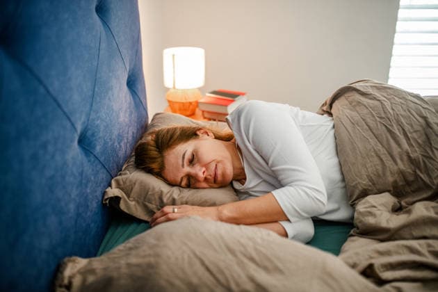 Tired middle aged woman sleeping in bed. Tired middle aged woman sleeping in bed in bedroom. model released