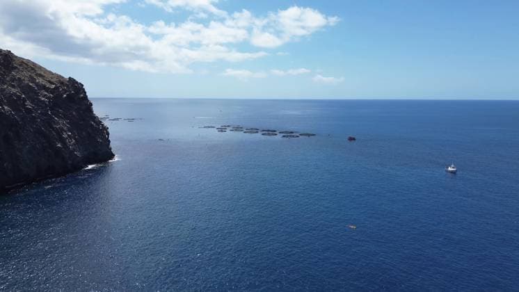 Coastline of Atlantic Ocean with Fish farms and a Boat to a sunny Day 1127164958