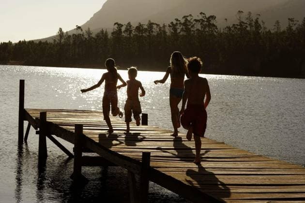 Children Running On Jetty At Lake - Rear view of young boys and girls running on jetty at lake model released Symbolfoto Copyright: xmoodboardx Panthermedia75390914.jpg