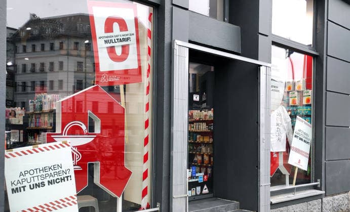 10 04 2026, Berlin Germany Posters in shop windows draw attention to the situation of pharmacies