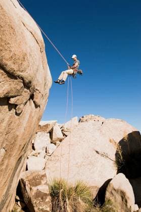 Man Rappelling From Cliff - Low angle view of a young man rappelling from cliff against clear blue sky model released Symbolfoto Copyright: xmoodboardx Panthermedia75337646.jpg