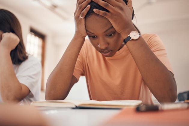 Exam stress, studying and student reading, classroom learning and headache from education. Anxiety, books and African girl with fear of fail on a test, adhd problem and frustrated with school. (License=RF) ,model released, Symbolfoto  Copyright: xZoonar.com YurixArcursxpeopleimages.comx 19536281 ,model released, Symbolfoto ,property released