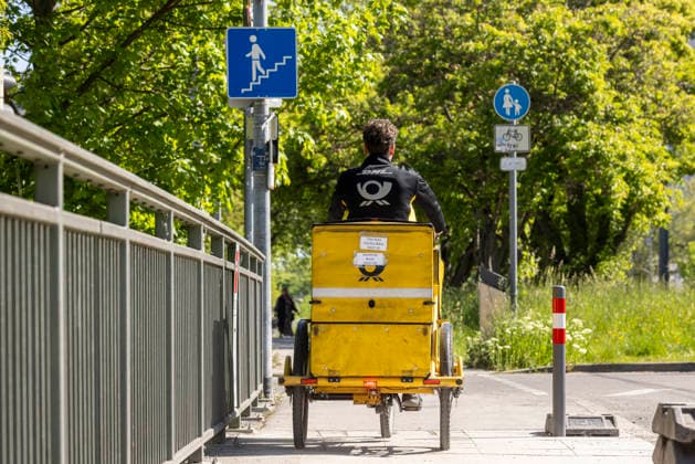 Letter carrier on the road with his bicycle 29 04 2026, Stuttgart, Baden Württemberg, Germany