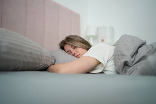 Ruhiger Schlaf, eingehüllt in sanftes Morgenlicht A woman rests deeply on her pillow, wrapped in muted bedding as gentle daylight softens the room and creates a serene moment of quiet recovery and stillness. (License=RM) ,model released, Symbolfoto Copyright: xZoonar.com SergeyxMironovx 24987810 ,model released, Symbolfoto ,property released