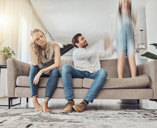 Family life stress, parents and child, chaos at home and energy, motion blur and burnout headache. Kid jump on couch, woman has migraine and man calming girl, hyperactive with ADHD and mental health. (License=RF) ,model released, Symbolfoto Copyright: xZoonar.com YurixArcursxpeopleimages.comx 19824752 ,model released, Symbolfoto ,property released