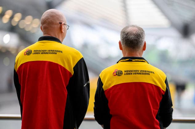 Feature, employees in DHL clothing with the slogan Connecting people, improving lives Annual General Meeting of Deutsche Post AG, on 05 05 2026 in Bonn Germany @ World Conference Center