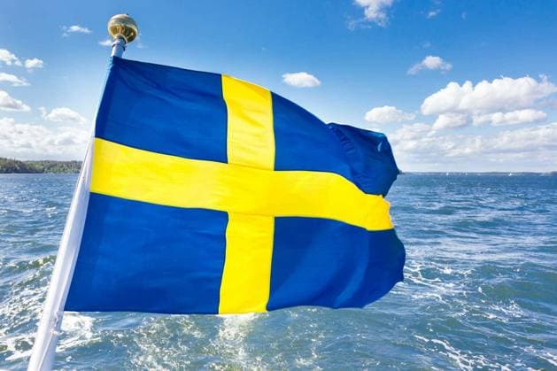 Swedish national flag fluttering on a wooden pole of a boat. Copyright: xkastox Panthermedia72374568.jpg
