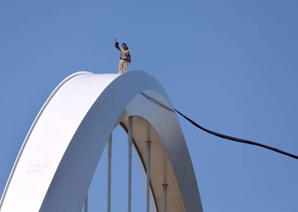May 5, 2026, Washington, District Of Columbia, USA: Activist Guido Reichstadter stands and waves to other protesters down on the ground as he remains atop the Frederick Douglass Memorial Bridge in Washington DC, USA, on May 05, 2026. Reichstadter climbed onto the bridge on May 1 and has remained there in protest of what he described as the Trump regime s war in Iran and against AI development. Washington USA - ZUMAs337 20260505_znp_s337_008 Copyright: xGentxShkullakux