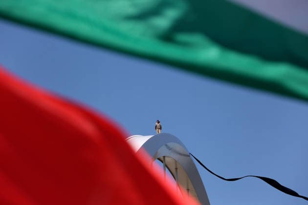 May 5, 2026, Washington, District Of Columbia, USA: Activist Guido Reichstadter sits atop the Frederick Douglass Memorial Bridge as protesters below hold Iranian and Palestinian flags in Washington DC, USA, on May 05, 2026. Reichstadter climbed onto the bridge on May 1 and has remained there in protest of what he described as the Trump regime s war in Iran and against AI development. Washington USA - ZUMAs337 20260505_znp_s337_001 Copyright: xGentxShkullakux