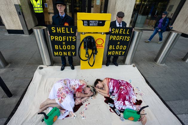 Climate Activists Pour Fake Blood over Protesters at Mock Petrol Pump outside Shell Centre, London, UK 6 May 2026 Activists lie on the ground in front of a mock petrol pump reading Oil Profit$$$ for Oil Bo$$es as they are doused in red liquid resembling blood outside the Shell Centre, London, UK, on 6 May 2026, during a Fossil Free London protest targeting Shell ahead of an expected jump in quarterly profits amid the US-Iran conflict., Credit:Pete Speller Avalon London, United Kingdom  Copyright: xPetexSpellerx xAvalonx 1096871571