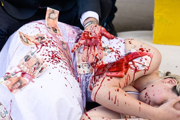 Climate Activists Pour Fake Blood over Protesters at Mock Petrol Pump outside Shell Centre, London, UK 6 May 2026 Activists lie on the ground in front of a mock petrol pump reading Oil Profit$$$ for Oil Bo$$es as they are doused in red liquid resembling blood outside the Shell Centre, London, UK, on 6 May 2026, during a Fossil Free London protest targeting Shell ahead of an expected jump in quarterly profits amid the US-Iran conflict., Credit:Pete Speller Avalon London, United Kingdom  Copyright: xPetexSpellerx xAvalonx 1096871596