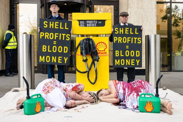 Climate Activists Pour Fake Blood over Protesters at Mock Petrol Pump outside Shell Centre, London, UK 6 May 2026 Activists lie on the ground in front of a mock petrol pump reading Oil Profit$$$ for Oil Bo$$es as they are doused in red liquid resembling blood outside the Shell Centre, London, UK, on 6 May 2026, during a Fossil Free London protest targeting Shell ahead of an expected jump in quarterly profits amid the US-Iran conflict., Credit:Pete Speller Avalon London, United Kingdom  Copyright: xPetexSpellerx xAvalonx 1096871605