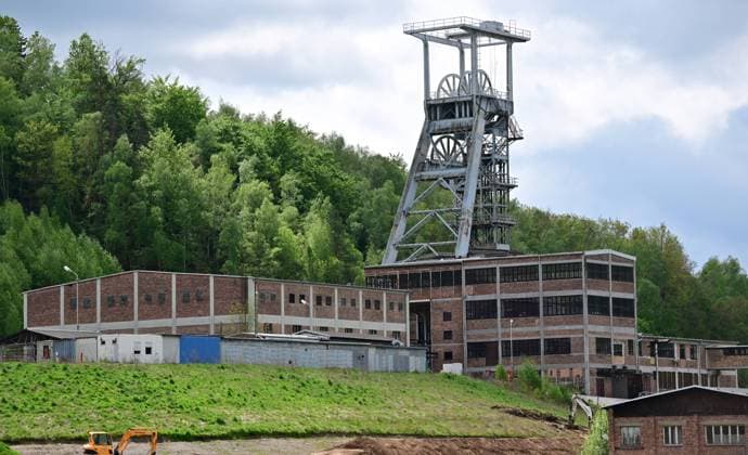 Neue Aussichtsplattform am Schacht 371 eröffnet Wismut macht Bergbaugeschichte erlebbar Neue Aussichtsplattform am Schacht 371 eröffnet Wismut macht Bergbaugeschichte erlebbar Die Wismut GmbH hat heute am traditionsreichen Schacht 371 bei Hartenstein eine neue Aussichtsplattform eröffnet und damit einen weiteren öffentlich zugänglichen Ort geschaffen, an dem die Geschichte des Uranerzbergbaus im Westerzgebirge sichtbar und erfahrbar wird. Im Bild: Blick auf die Übertageanlagenmit dem Fördergerüst. Der Standort zählt zu den bedeutendsten Anlagen des ehemaligen SDAG Wismut Bergbaus. Der Schacht war bis zu seiner Stilllegung 1991 das tiefste Bergwerk Deutschlands. Die neue Plattform bietet einen freien Blick auf Aue-Bad-Schlema_Wismut_031-0605-26