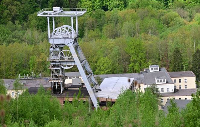 Neue Aussichtsplattform am Schacht 371 eröffnet Wismut macht Bergbaugeschichte erlebbar Neue Aussichtsplattform am Schacht 371 eröffnet Wismut macht Bergbaugeschichte erlebbar Die Wismut GmbH hat heute am traditionsreichen Schacht 371 bei Hartenstein eine neue Aussichtsplattform eröffnet und damit einen weiteren öffentlich zugänglichen Ort geschaffen, an dem die Geschichte des Uranerzbergbaus im Westerzgebirge sichtbar und erfahrbar wird. Im Bild: Blick auf die Übertageanlagenmit dem Fördergerüst. Der Standort zählt zu den bedeutendsten Anlagen des ehemaligen SDAG Wismut Bergbaus. Der Schacht war bis zu seiner Stilllegung 1991 das tiefste Bergwerk Deutschlands. Die neue Plattform bietet einen freien Blick auf Aue-Bad-Schlema_Wismut_029-0605-26