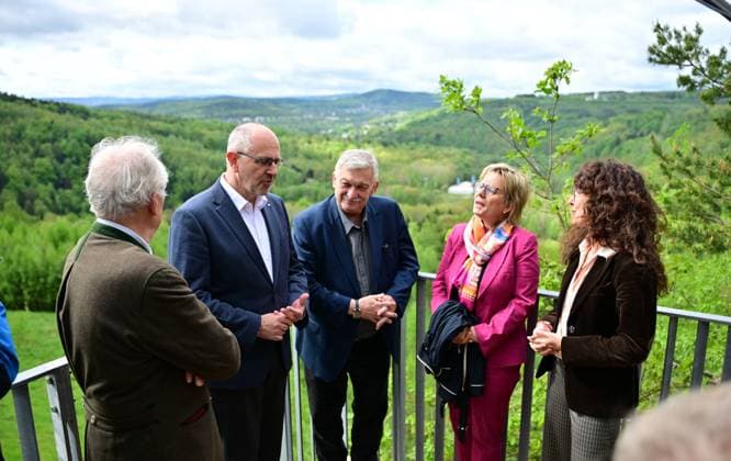 Neue Aussichtsplattform am Schacht 371 eröffnet Wismut macht Bergbaugeschichte erlebbar Die Wismut GmbH hat heute am traditionsreichen Schacht 371 bei Hartenstein eine neue Aussichtsplattform eröffnet und damit einen weiteren öffentlich zugänglichen Ort geschaffen, an dem die Geschichte des Uranerzbergbaus im Westerzgebirge sichtbar und erfahrbar wird. Im Bild vlnr.: Alfred Prinz von Schönburg‘Hartenstein, Bewohner und Eigentümer der Burg Stein und Eigentümer zahlreicher Forsten im ehemaligen Wismut TerritoriumDr. Michael Paul,Vorstand Wismut, Heinrich Kohl,Oberbürgermeister Aue-Schlema, Staatsministerin Bildung Tourismus Barbara Klepsch, Dr, Julia Dünkel, Wismutstiftung. Der Standort zählt zu den bedeutendsten Anlagen des Aue-Bad-Schlema_Wismut_024-0605-26