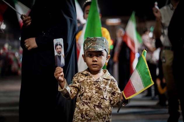 May 6, 2026, Iran, Iran: An Iranian boy wearing a fake military uniform holds a picture of Iran s newly appointed Supreme Leader, Ayatollah Mojtaba Khamenei, and the national flag during a state-organized rally, amid a ceasefire in the conflict involving Iran, the United States, and Israel. The United Kingdom, France, Germany, and Saudi Arabia called for de-escalation in the Middle East following reported attacks on May 4 on the United Arab Emirates. Iran s chief negotiator in talks with the United States warned on May 5 that his country has not even started in its standoff over the Strait of Hormuz. The United States and Pakistan, a key mediator in the Middle East war, expressed new hope of talks leading to a peace deal with Iran on Ma - ZUMAi98_ 20260506_zih_i98_007 Copyright: xIranianxSupremexLeader SxOfficex