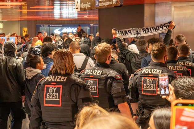 Police officers escort French soccer fans in the Marienplatz underground station mezzanine, PSG fans take the U3 to the Champions League semi-final between