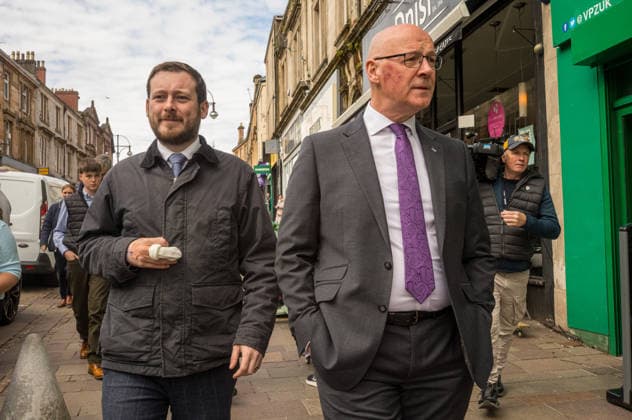 First Minister of Scotland John Swinney joins SNP candidate Alex Kerr campaigning in Hamilton - 06 May 2026 First Minister of Scotland John Swinney (right) and SNP candidate Alex Kerr (left) walk together through the constituency. The day before the Scottish parliamentary elections, First Minister of Scotland John Swinney visits Hamilton in South Lanarkshire, the constituency of SNP candidate Alex Kerr to kick off the final day of campaigning by meeting potential voters and owners of local businesses. Hamilton United Kingdom Copyright: xNeilxMiltonx xSOPAxImagesx L1000756