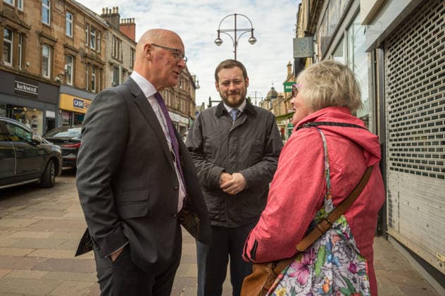 First Minister of Scotland John Swinney joins SNP candidate Alex Kerr campaigning in Hamilton - 06 May 2026 First Minister of Scotland John Swinney (left) and SNP candidate Alex Kerr (centre) meet a member of the Hamilton constituency. The day before the Scottish parliamentary elections, First Minister of Scotland John Swinney visits Hamilton in South Lanarkshire, the constituency of SNP candidate Alex Kerr to kick off the final day of campaigning by meeting potential voters and owners of local businesses. Hamilton United Kingdom Copyright: xNeilxMiltonx xSOPAxImagesx L1000736