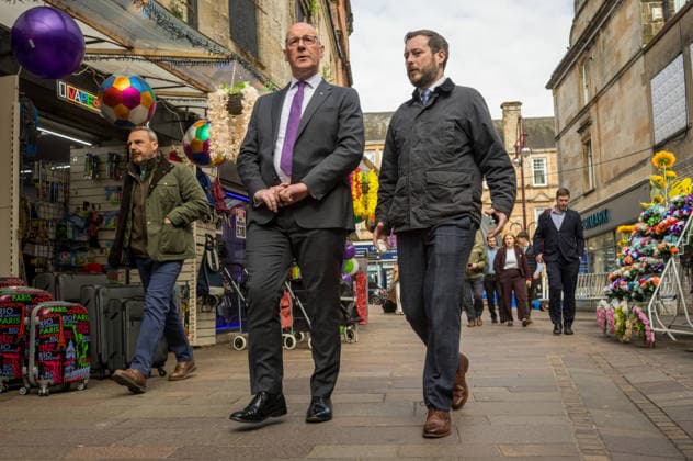 First Minister of Scotland John Swinney joins SNP candidate Alex Kerr campaigning in Hamilton - 06 May 2026 First Minister of Scotland John Swinney (right) and SNP candidate Alex Kerr (left) walk together through the constituency. The day before the Scottish parliamentary elections, First Minister of Scotland John Swinney visits Hamilton in South Lanarkshire, the constituency of SNP candidate Alex Kerr to kick off the final day of campaigning by meeting potential voters and owners of local businesses. Hamilton United Kingdom Copyright: xNeilxMiltonx xSOPAxImagesx L1000792