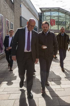First Minister of Scotland John Swinney joins SNP candidate Alex Kerr campaigning in Hamilton - 06 May 2026 First Minister of Scotland John Swinney (left) and SNP candidate Alex Kerr (right) walk together through the constituency. The day before the Scottish parliamentary elections, First Minister of Scotland John Swinney visits Hamilton in South Lanarkshire, the constituency of SNP candidate Alex Kerr to kick off the final day of campaigning by meeting potential voters and owners of local businesses. Hamilton United Kingdom Copyright: xNeilxMiltonx xSOPAxImagesx L1000934