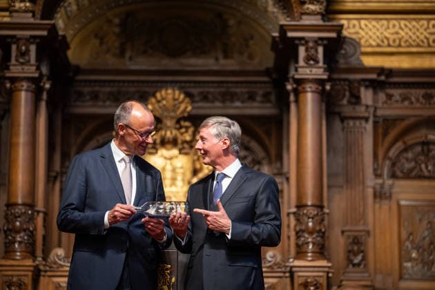 Friedrich Merz, Federal Chancellor, after his speech at Hamburg City Hall, with Harald Vogelsang, President of the Overseas Club and Chairman of the Board of Hamburger Sparkasse, at the presentation of a ship in a bottle as a traditional gift 76 Great Overseas Day in Hamburg, April 2026 Ceremony at Hamburg City Hall, Hamburg Hamburg Germany City Hall