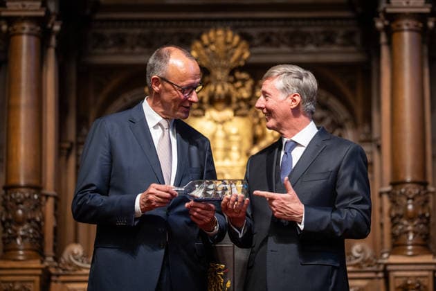 Friedrich Merz, Federal Chancellor, after his speech at Hamburg City Hall, with Harald Vogelsang, President of the Overseas Club and Chairman of the Board of Hamburger Sparkasse, at the presentation of a ship in a bottle as a traditional gift 76 Great Overseas Day in Hamburg, April 2026 Ceremony at Hamburg City Hall, Hamburg Hamburg Germany City Hall