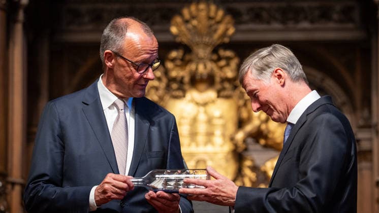 Friedrich Merz, Federal Chancellor, after his speech at Hamburg City Hall, with Harald Vogelsang, President of the Overseas Club and Chairman of the Board of Hamburger Sparkasse, at the presentation of a ship in a bottle as a traditional gift 76 Great Overseas Day in Hamburg, April 2026 Ceremony at Hamburg City Hall, Hamburg Hamburg Germany City Hall