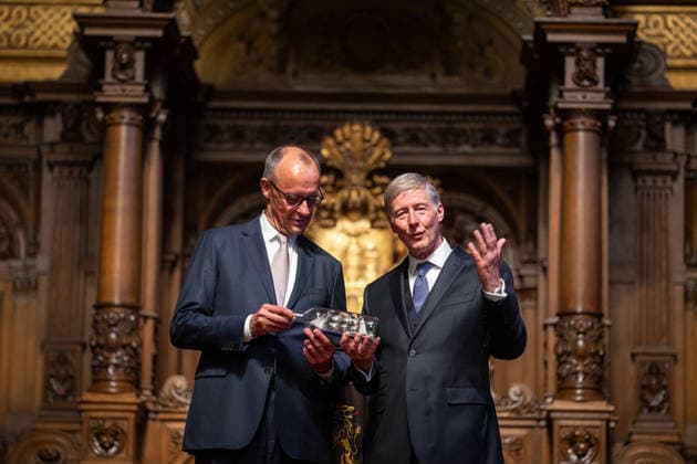 Friedrich Merz, Federal Chancellor, after his speech at Hamburg City Hall, with Harald Vogelsang, President of the Overseas Club and Chairman of the Board of Hamburger Sparkasse, at the presentation of a ship in a bottle as a traditional gift 76 Great Overseas Day in Hamburg, April 2026 Ceremony at Hamburg City Hall, Hamburg Hamburg Germany City Hall