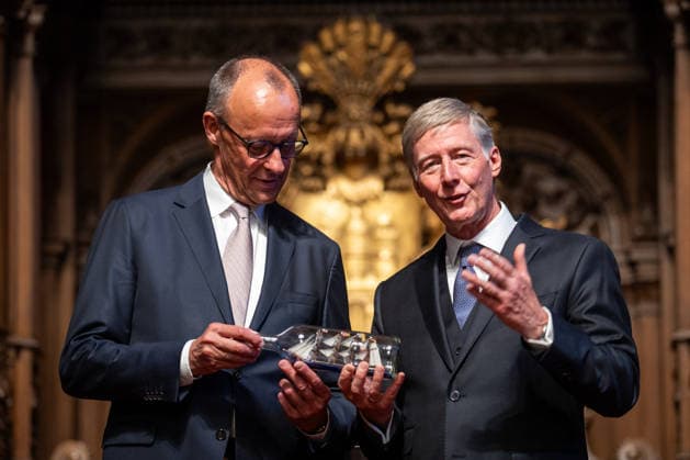 Friedrich Merz, Federal Chancellor, after his speech at Hamburg City Hall, with Harald Vogelsang, President of the Overseas Club and Chairman of the Board of Hamburger Sparkasse, at the presentation of a ship in a bottle as a traditional gift 76 Great Overseas Day in Hamburg, April 2026 Ceremony at Hamburg City Hall, Hamburg Hamburg Germany City Hall