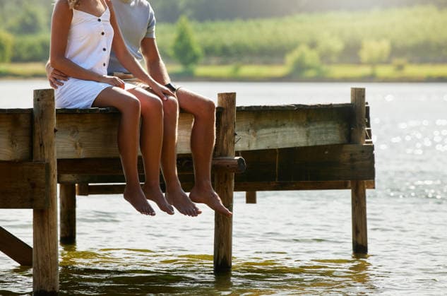 Couple together in nature, relax by lake and summer, travel and adventure, love and care outdoor. People in relationship, trust and bonding on vacation, man and woman sitting on jetty with freedom. (License=RF) ,model released, Symbolfoto Copyright: xZoonar.com YurixArcursxpeopleimages.comx 20038567 ,model released, Symbolfoto ,property released