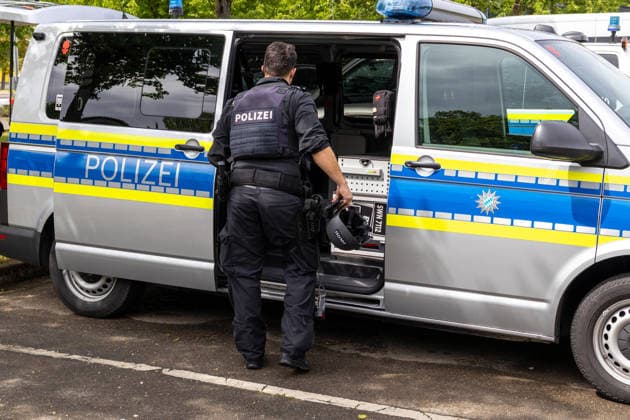 Germany, Bavaria, Augsburg, Pfersee May 7, 2026: Major police operation in the area of Ulrich-Schwarz-Straße in Augsburg Pfersee. A police officer is removing equipment from a patrol car at the scene.
