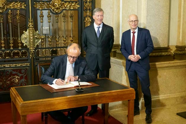 CNTV FEDERAL CHANCELLOR Peter Tschentscher SPD politician and First Mayor of Hamburg Friedrich Merz CDU politician the Federal Chancellor with Harald Vogelsang, President Uebersee Club and Chairman of the Board Hamburger Sparkasse at the Uebersee Day in Hamburg City Hall on 07 05 2026 at the entry in the Golden Book of the Uebersee Club Hamburg Germany