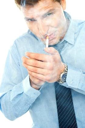 Young man lighting a cigarette against white background model released Symbolfoto Copyright: xstockyimagesx Panthermedia70611598.jpg