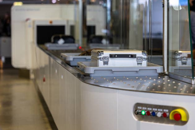 Opening of the new CT checkpoint at Nuremberg Airport, Nuremberg, 08 05 2026 Baggage tray with transport case on the conveyor system of the new CT checkpoint at Nuremberg Airport A CT scanner from Smiths Detection for passenger screening can be seen in the background Nuremberg Bavaria Germany 20260508-1V9A7943-M4000