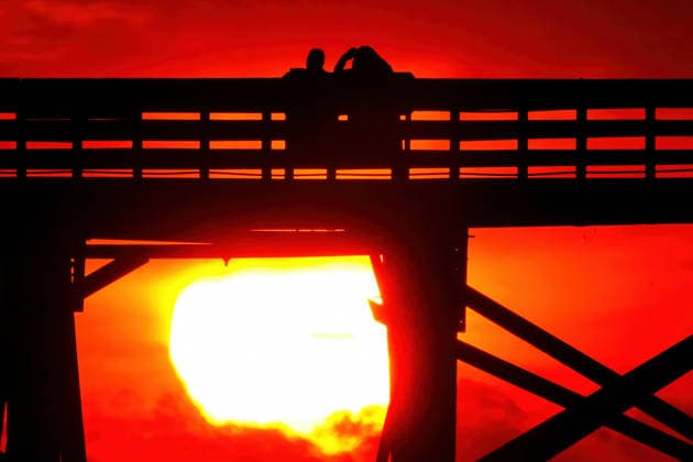 May 8, 2026, Isle Of Palms, Sc, United States: A couple sitting on the Isle of Palms Pier are silhouetted by orange light or the sun as it rises over the Atlantic Ocean horizon on Front Beach, May 8, 2026 in Isle of Palms, South Carolina. Isle Of Palms United States - ZUMAe02_ 20260508_zaf_e02_005 Copyright: xRichardxEllisx