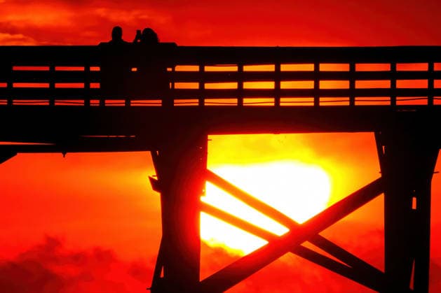 May 8, 2026, Isle Of Palms, Sc, United States: A couple sitting on the Isle of Palms Pier are silhouetted by orange light or the sun as it rises over the Atlantic Ocean horizon on Front Beach, May 8, 2026 in Isle of Palms, South Carolina. Isle Of Palms United States - ZUMAe02_ 20260508_zaf_e02_006 Copyright: xRichardxEllisx