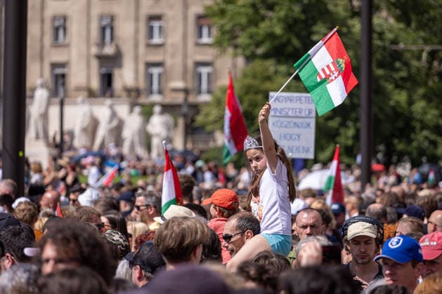 May 9, 2026, Budapest, Hungary: A young girl holding a flag of Hungary stands among the crowds at Lajos Kossuth Square, listening to the speech during the inauguration of Peter Magyar in Budapest Budapest Hungary  - ZUMAl194 20260509_zip_l194_018 Copyright: xMarekxLadzinskix