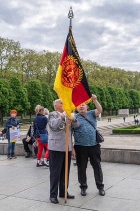 A former officer of the National Peoples Army NVA of the GDR with a GDR flag on May 9, Victory Day, at the Soviet Memorial in Treptower Park in Berlin Treptow