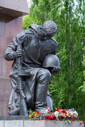 Flowers at the kneeling Red Army soldier on May 9, Victory Day, at the Soviet Memorial in Treptower Park in Berlin Treptow