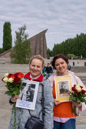 Two Russian women with photos of family members who died in the Second World War on May 9, Victory Day, at the Soviet Memorial in Treptower Park in Berlin Treptow