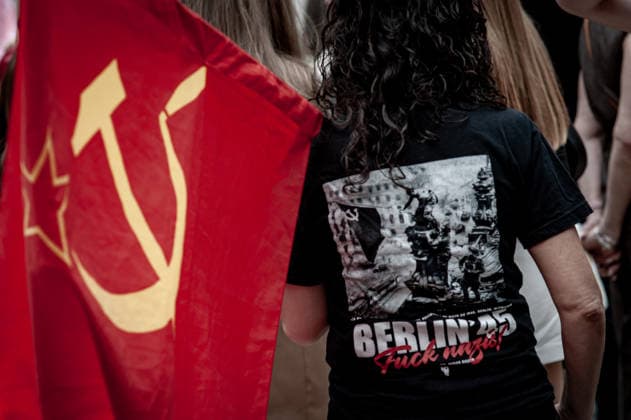 May 9, 2026, Barcelona, Spain: A participant wearing a shirt referencing the Battle of Berlin stands beside a Soviet flag during an Immortal Regiment gathering in Barcelona marking Victory Day, commemorating the Soviet Union s victory over Nazi Germany in World War II. Barcelona Spain - ZUMAb137 20260509_fap_b137_009 Copyright: xJordixBoixareux
