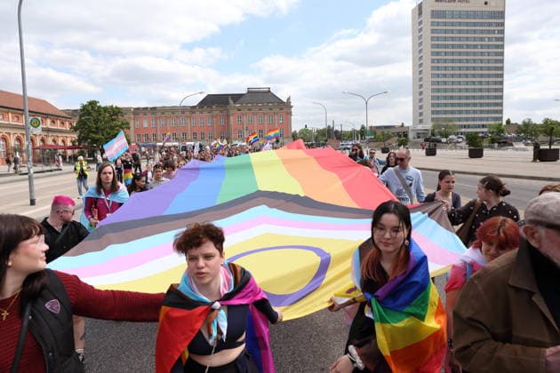 People walk with a rainbow flag on Breite Straße during a demonstration for Christopher Street Day in Potsdam, May 9, 2026 CSD in Potsdam