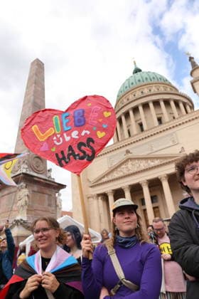 People stand with sign Love over hate on the Old Market during a demonstration for Christopher Street Day in Potsdam, May 9, 2026 CSD in Potsdam