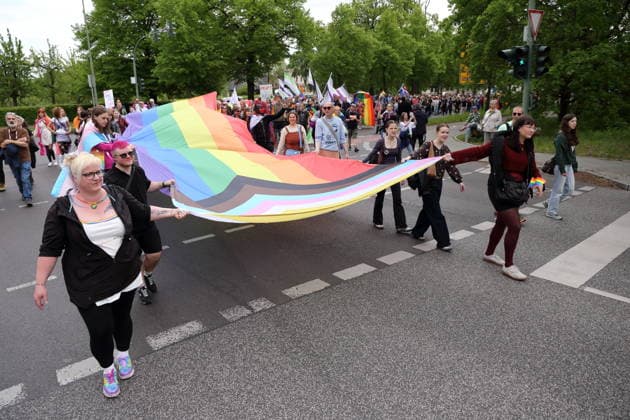 People walk with a rainbow flag in the Pappelallee during a demonstration for Christopher Street Day in Potsdam, May 9, 2026 CSD in Potsdam