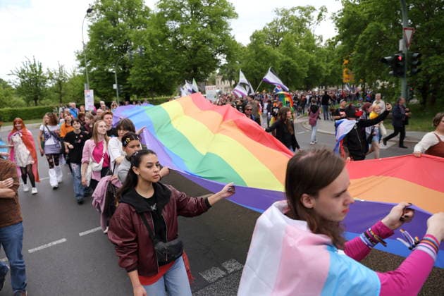 People walk with a rainbow flag in the Pappelallee during a demonstration for Christopher Street Day in Potsdam, May 9, 2026 CSD in Potsdam